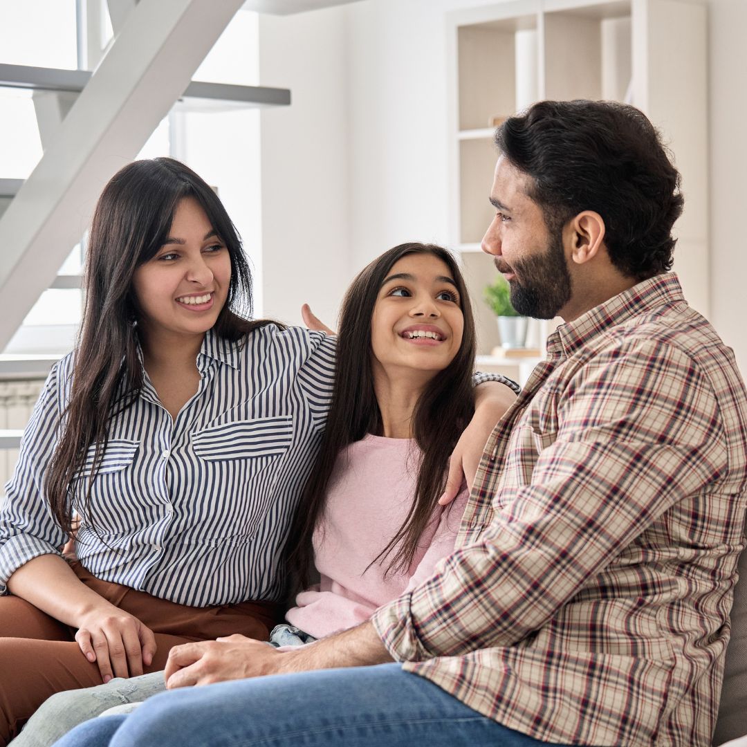 family sitting on couch smiling